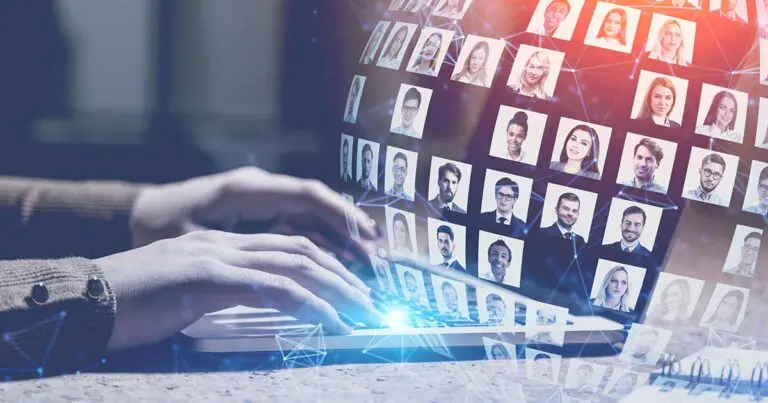 Image of a person typing on a keyboard with a holographic display of diverse professional headshots forming a digital globe above the laptop. The futuristic interface suggests global networking, online recruiting, and the power of digital connections in job searching and career advancement.